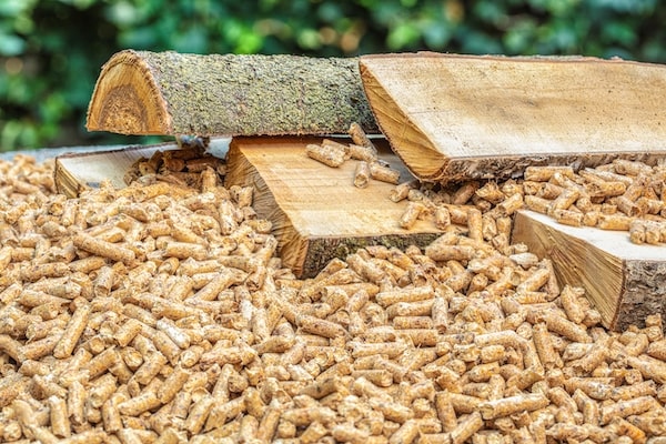 Grand nombre de pellets de bois avec des bûches de bois